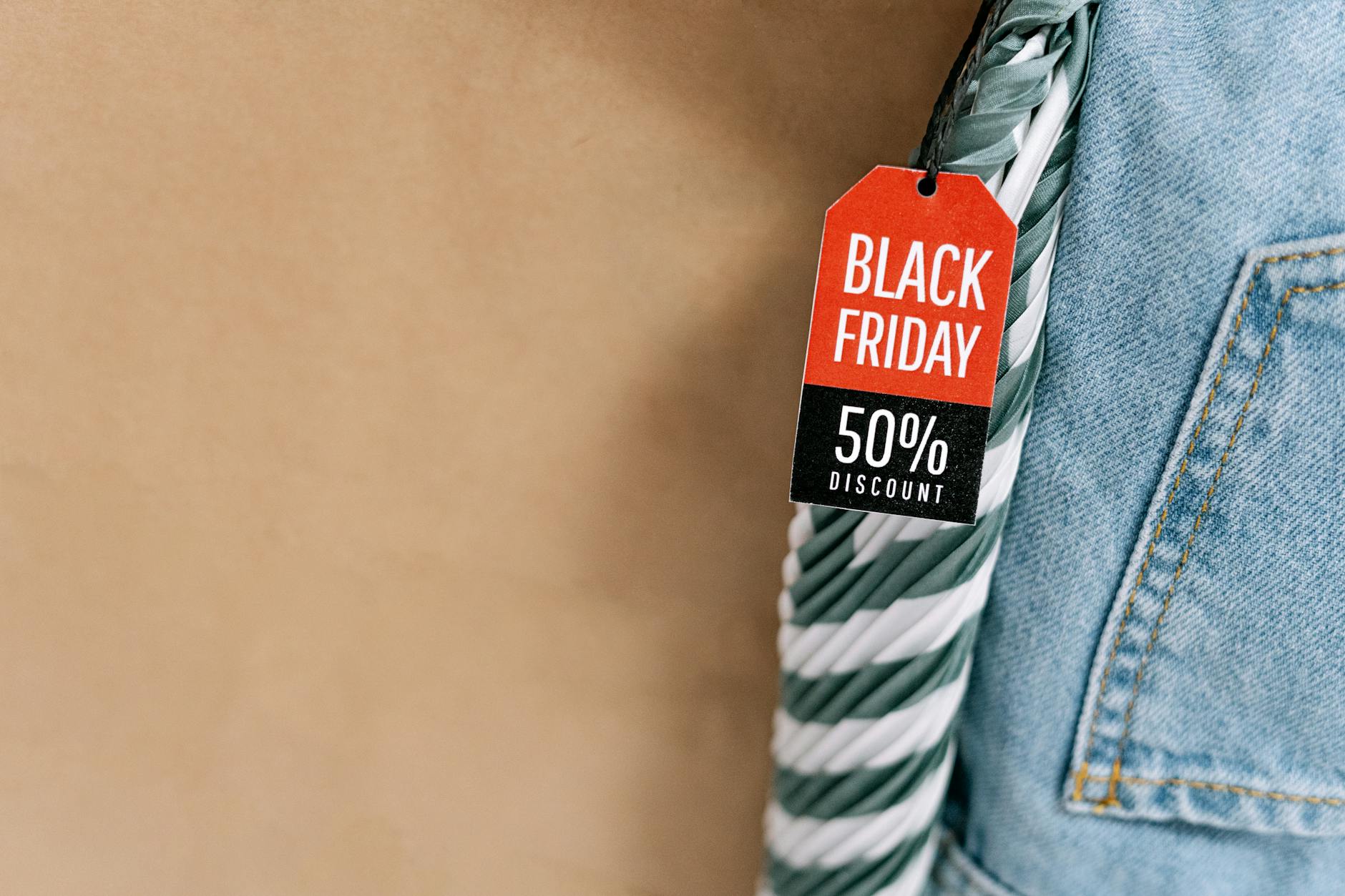 Metka Black Friday -50% na dżinsach z uchwytem torby na brązowym tle