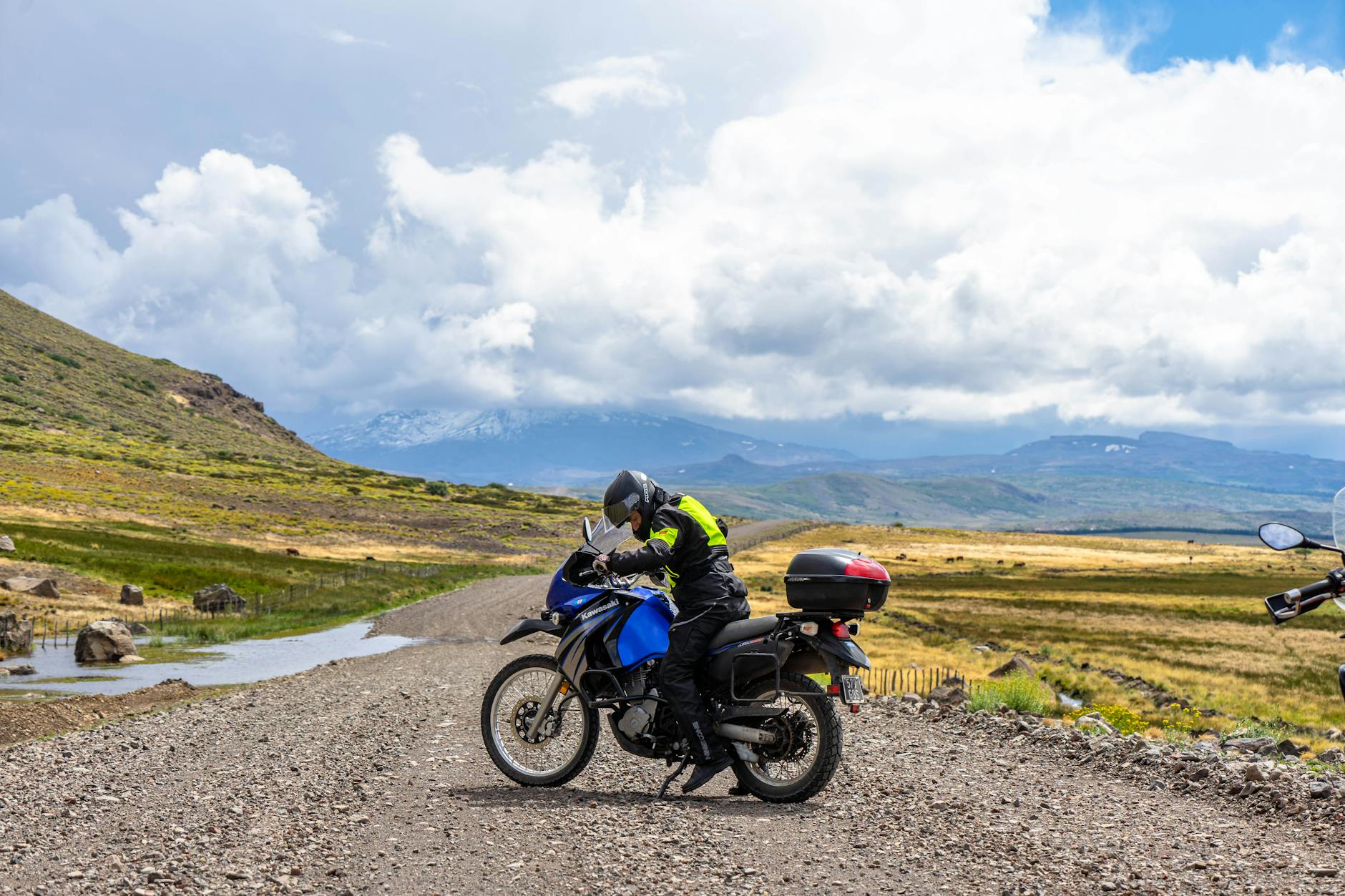Motocyklista turystyczny jedzie przez górzysty krajobraz Neuquén w chmurach