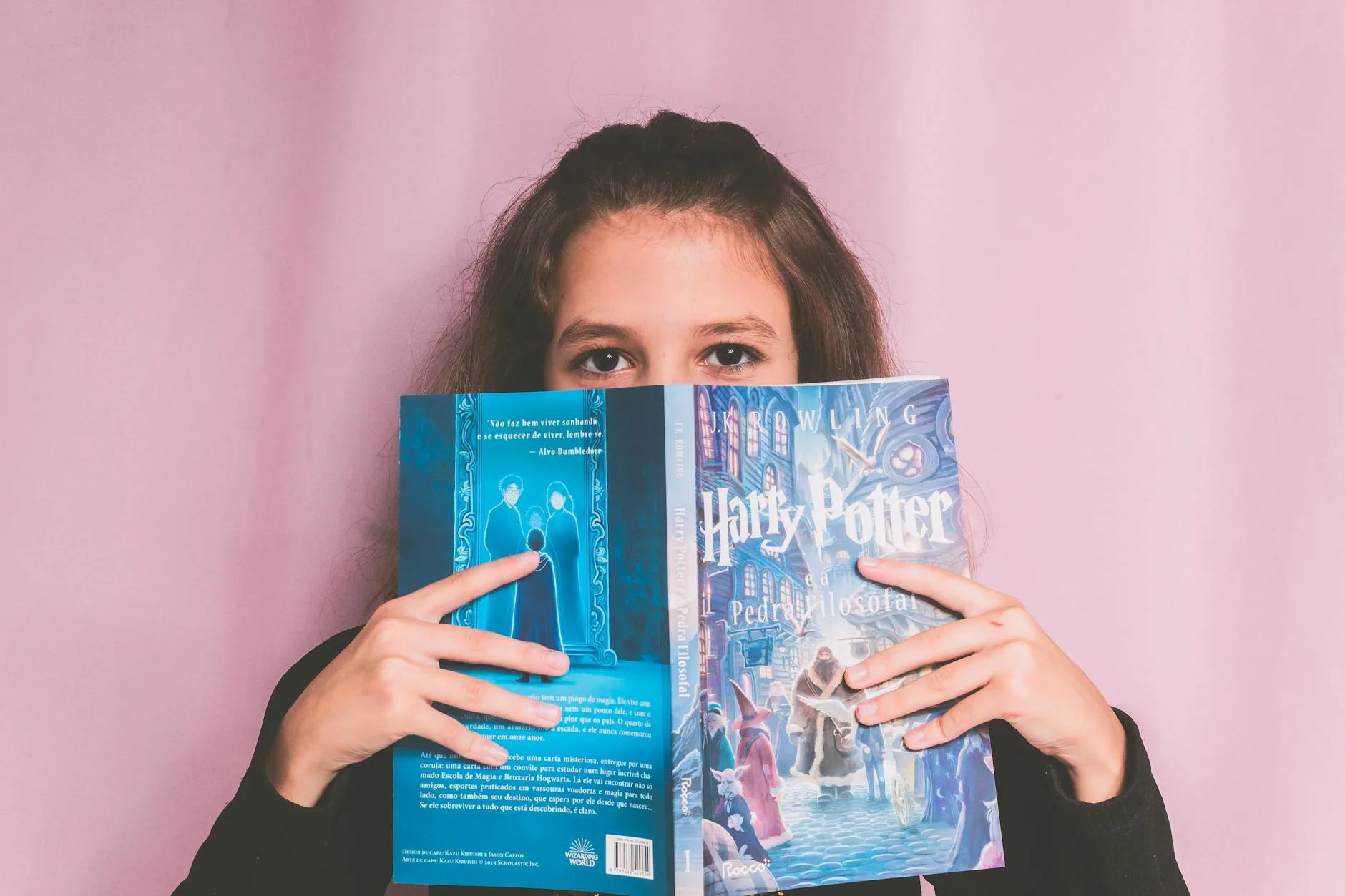 Dziewczyna z książką Harry Potter na różowym tle