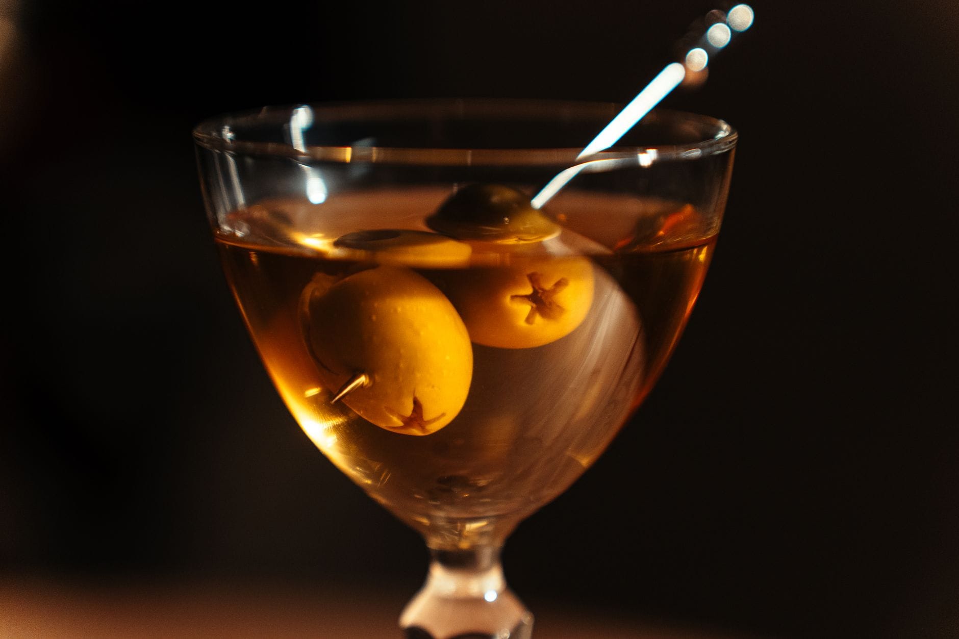 Klasyczne martini z oliwkami w kieliszku, zbliżenie w barze koktajlowym